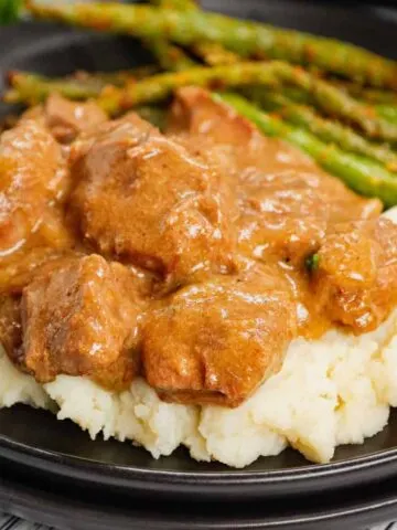 Crock Pot Beef Tips is a delicious slow cooker dinner recipe made with chunks of stewing beef, sliced onions, cream of mushroom soup, beef broth and beef gravy mix.