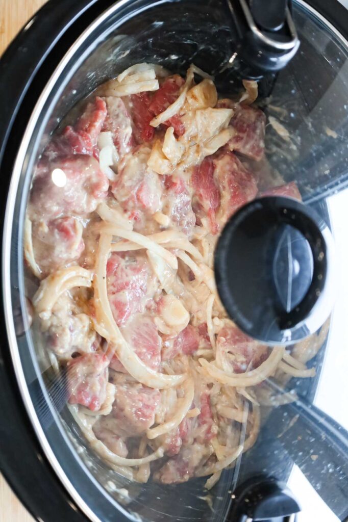 lid on crock pot with stewing beef mixture in it