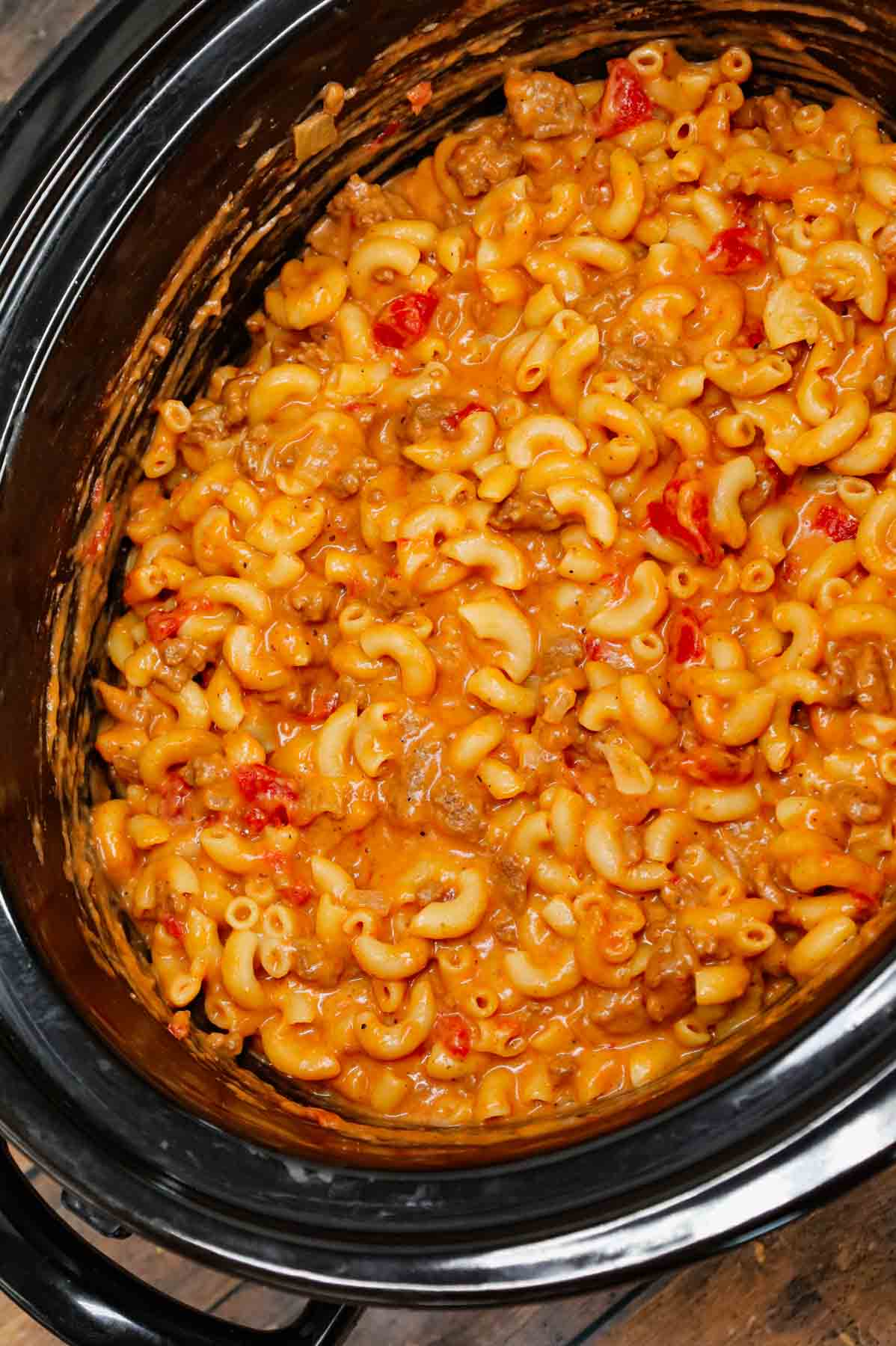 Crock Pot Hamburger Helper is a hearty slow cooker dish loaded with ground beef, diced onions, diced tomatoes, macaroni, cheddar soup and shredded cheddar cheese.