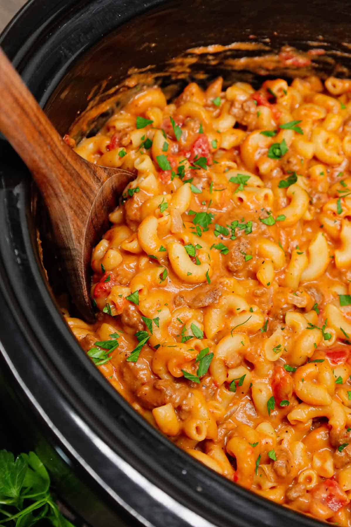 Crock Pot Hamburger Helper is a hearty slow cooker dish loaded with ground beef, diced onions, diced tomatoes, macaroni, cheddar soup and shredded cheddar cheese.