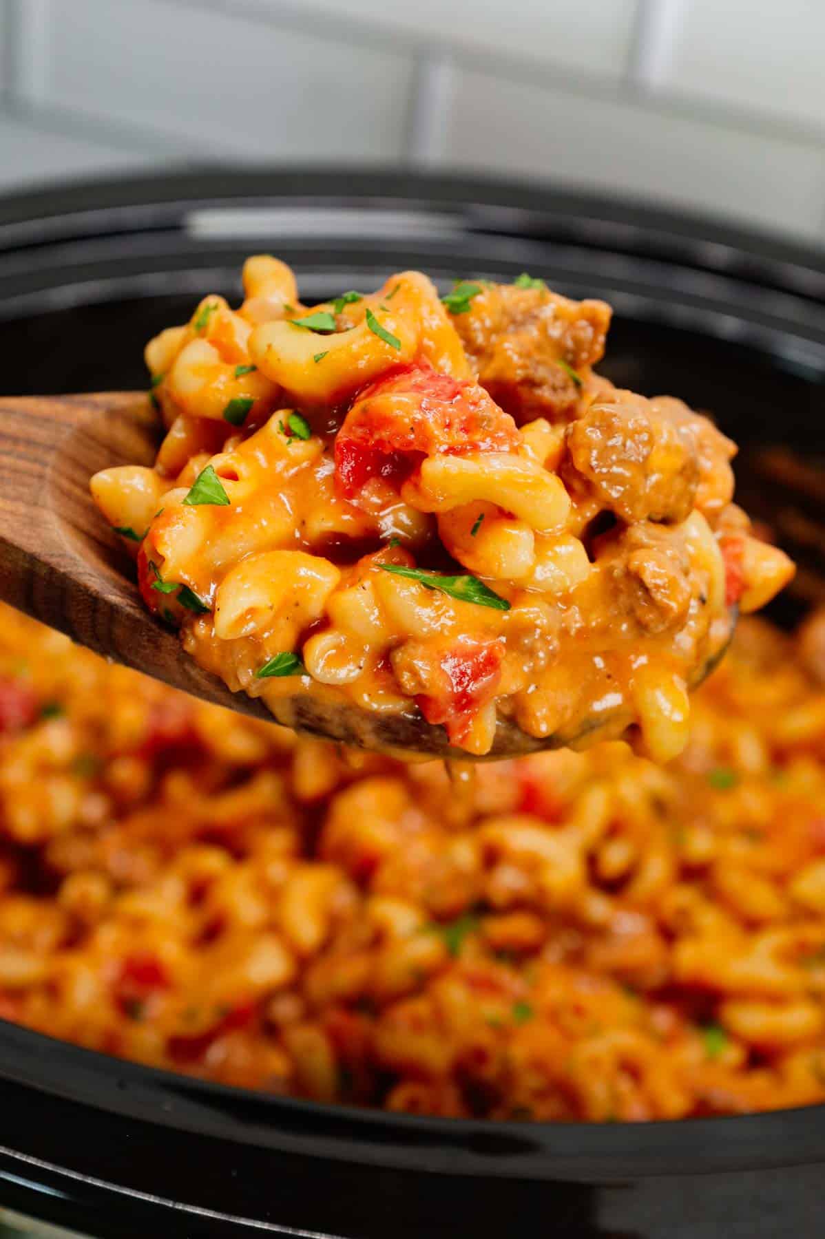 Crock Pot Hamburger Helper is a hearty slow cooker dish loaded with ground beef, diced onions, diced tomatoes, macaroni, cheddar soup and shredded cheddar cheese.