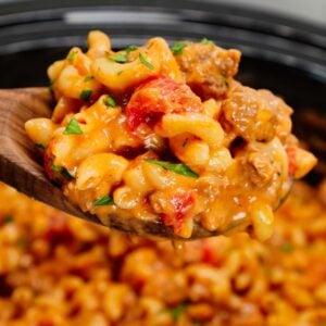 Crock Pot Hamburger Helper is a hearty slow cooker dish loaded with ground beef, diced onions, diced tomatoes, macaroni, cheddar soup and shredded cheddar cheese.