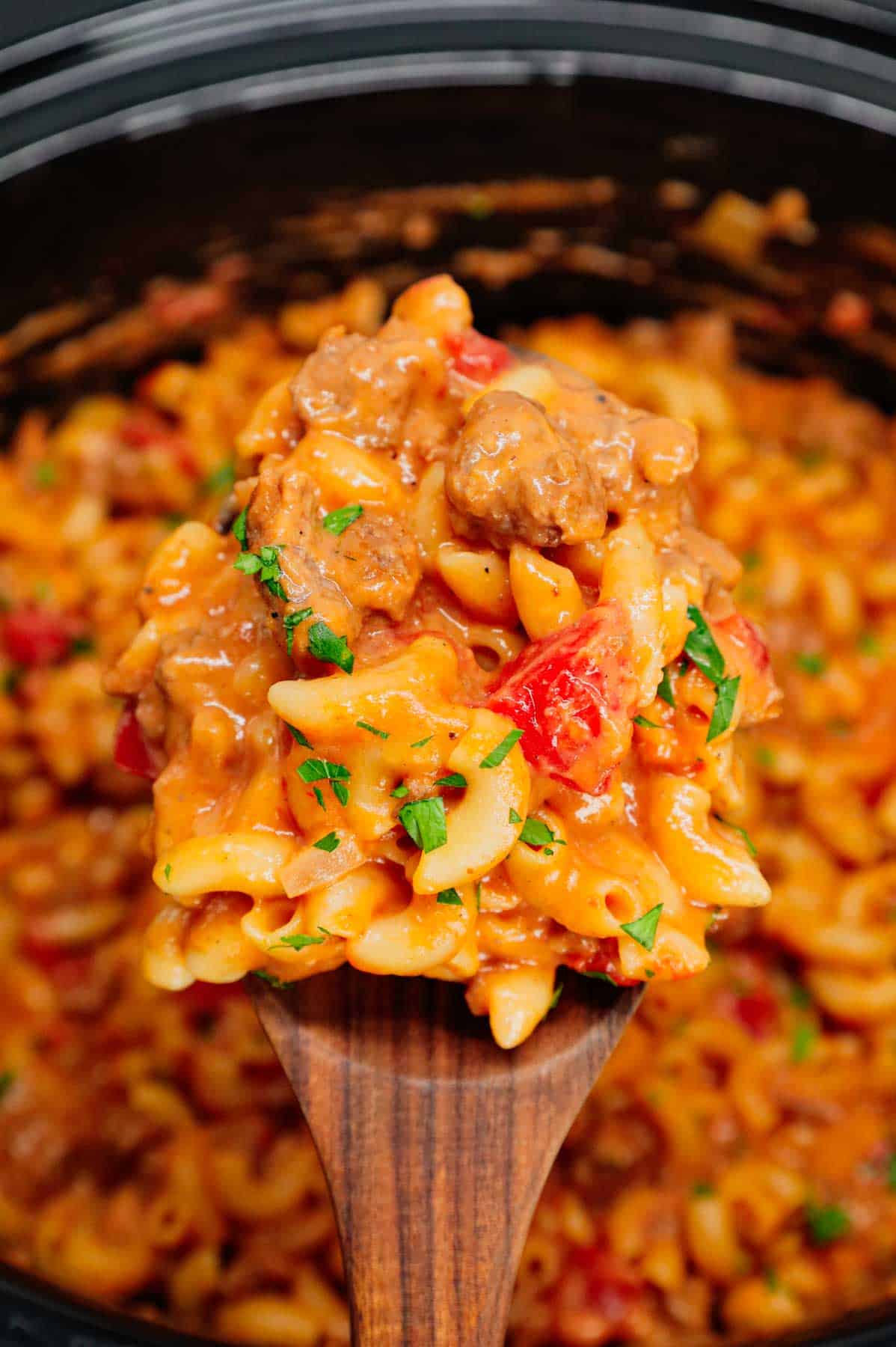 Crock Pot Hamburger Helper is a hearty slow cooker dish loaded with ground beef, diced onions, diced tomatoes, macaroni, cheddar soup and shredded cheddar cheese.