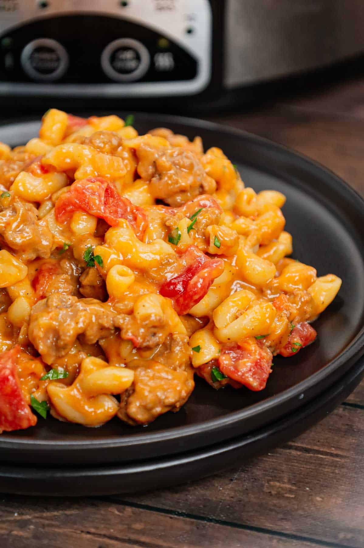 Crock Pot Hamburger Helper is a hearty slow cooker dish loaded with ground beef, diced onions, diced tomatoes, macaroni, cheddar soup and shredded cheddar cheese.