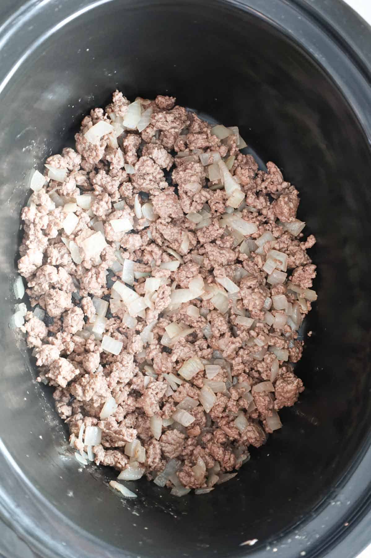 cooked ground beef and diced onions in a Crock Pot