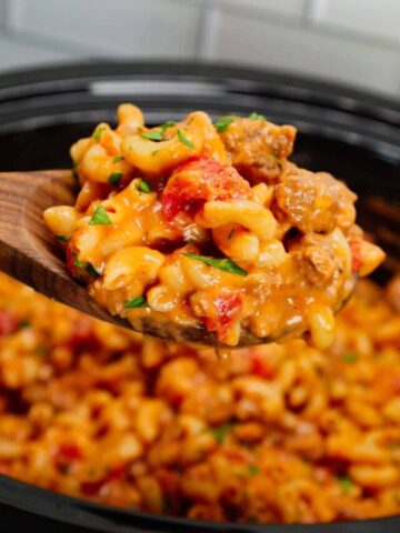 Crock Pot Hamburger Helper is a hearty slow cooker dish loaded with ground beef, diced onions, diced tomatoes, macaroni, cheddar soup and shredded cheddar cheese.