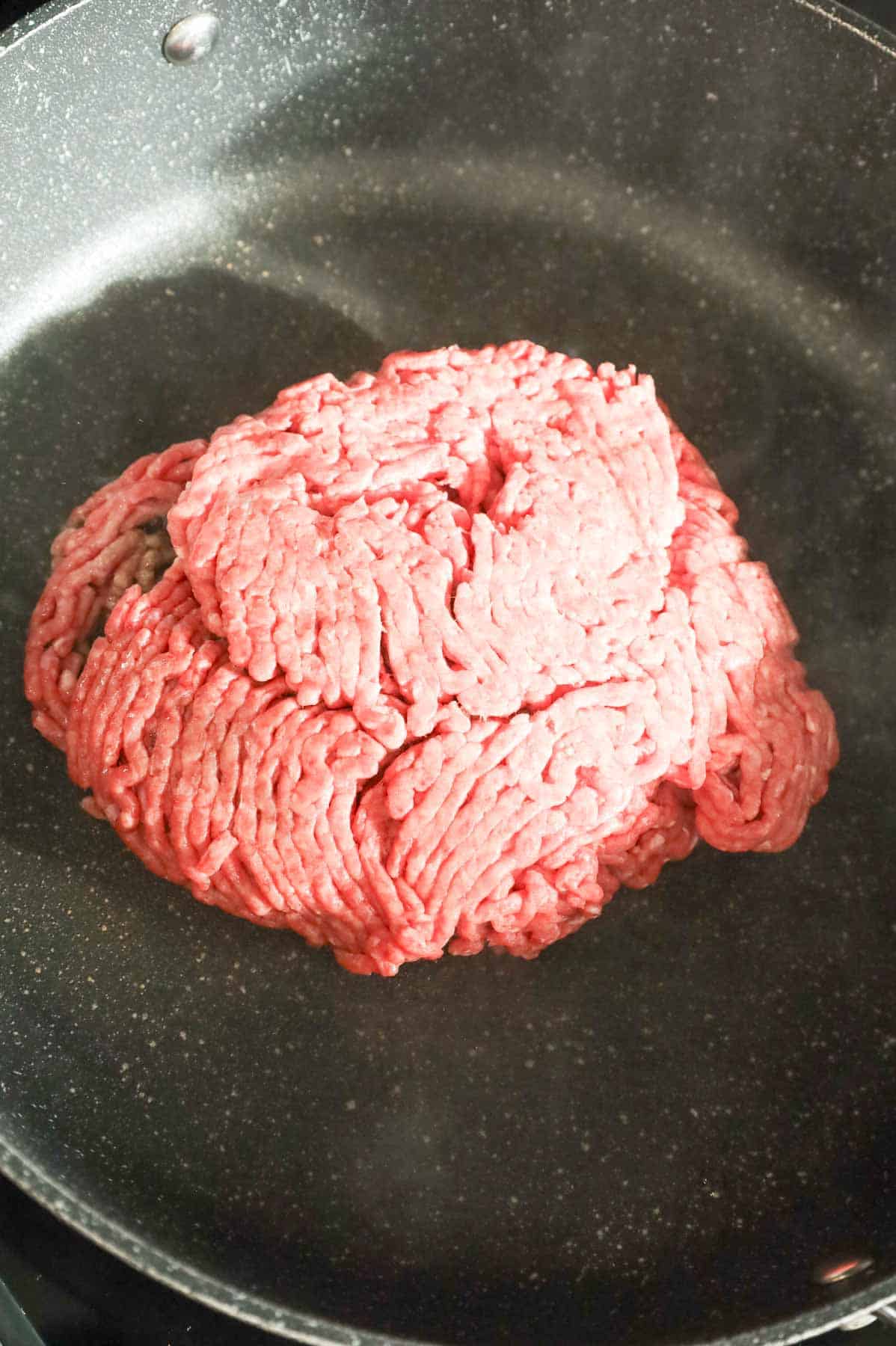 raw ground beef in a skillet