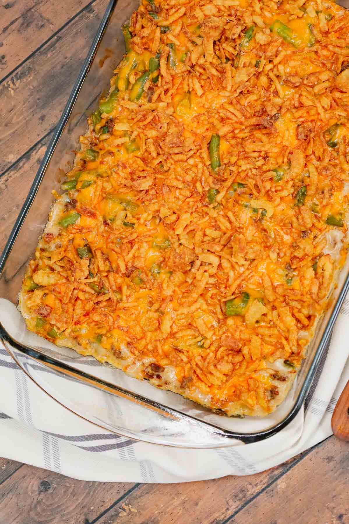 Hamburger Green Bean Casserole is a hearty ground beef casserole recipe loaded with cut green beans, cream of mushroom soup, diced onions, shredded cheddar cheese and French's crispy fried onions.