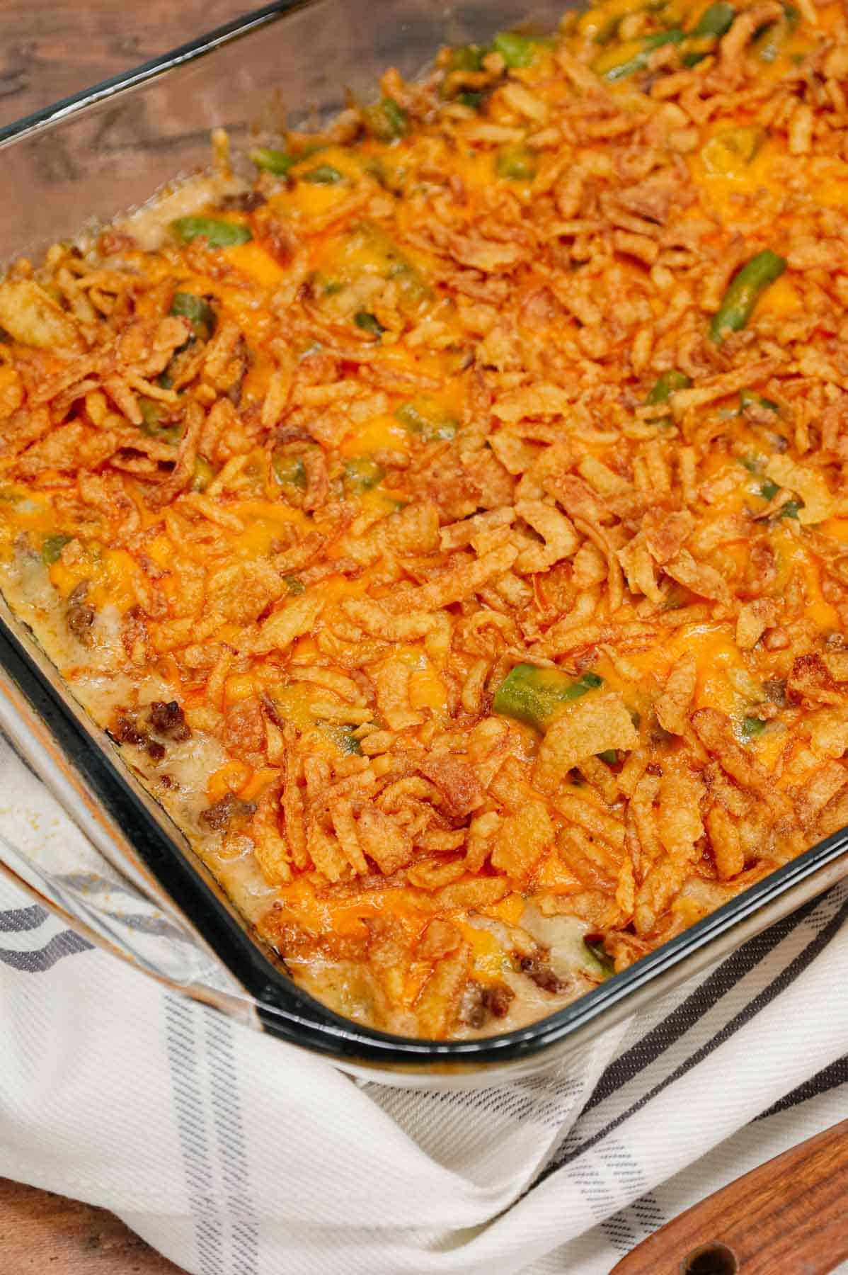 Hamburger Green Bean Casserole is a hearty ground beef casserole recipe loaded with cut green beans, cream of mushroom soup, diced onions, shredded cheddar cheese and French's crispy fried onions.