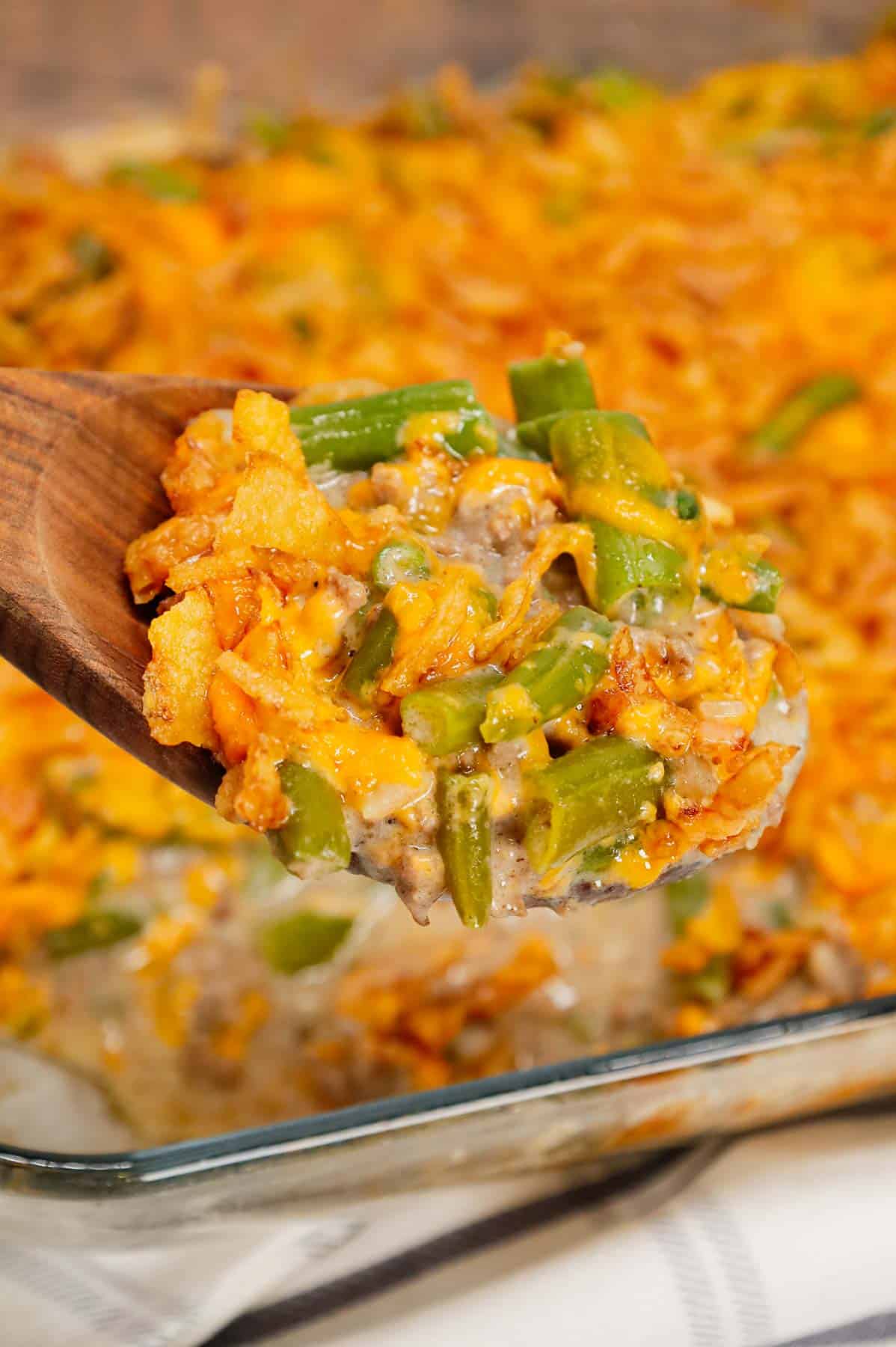 Hamburger Green Bean Casserole is a hearty ground beef casserole recipe loaded with cut green beans, cream of mushroom soup, diced onions, shredded cheddar cheese and French's crispy fried onions.