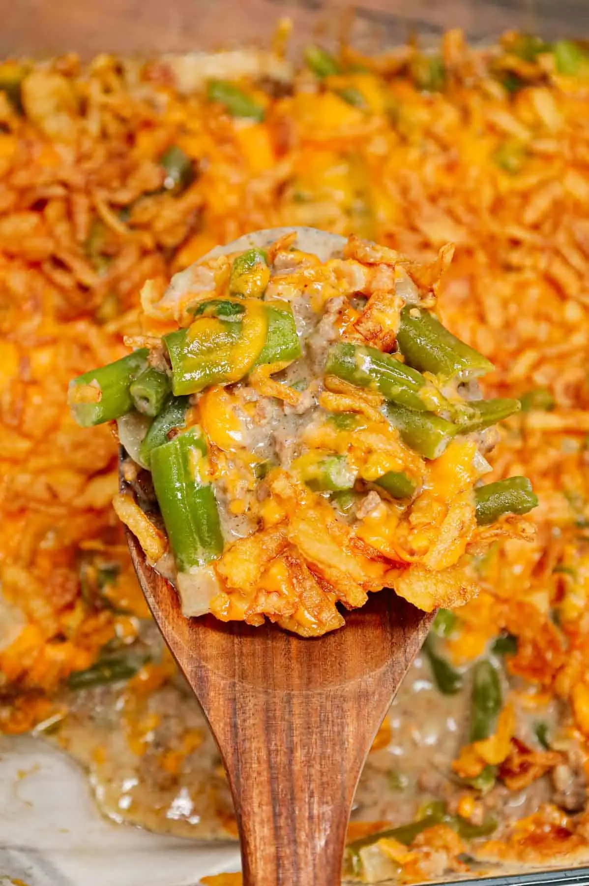 Hamburger Green Bean Casserole is a hearty ground beef casserole recipe loaded with cut green beans, cream of mushroom soup, diced onions, shredded cheddar cheese and French's crispy fried onions.