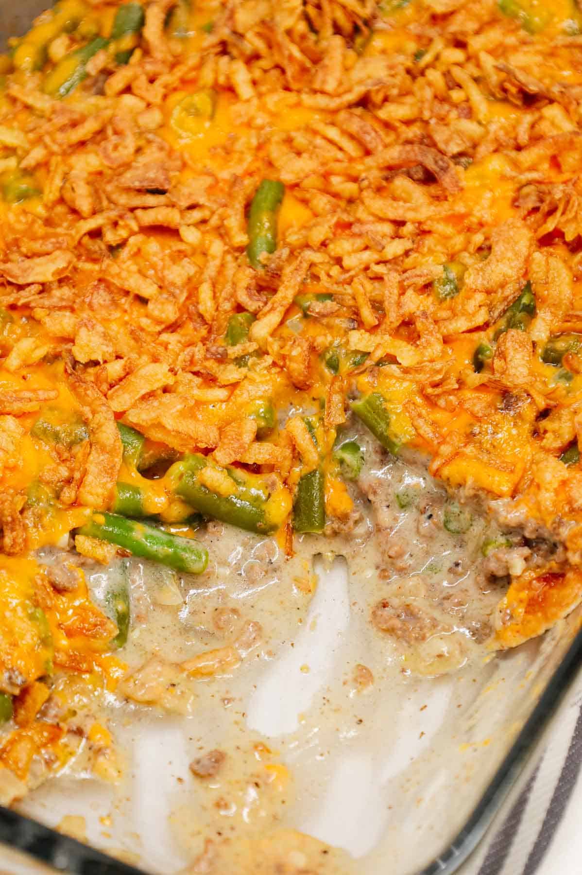 Hamburger Green Bean Casserole is a hearty ground beef casserole recipe loaded with cut green beans, cream of mushroom soup, diced onions, shredded cheddar cheese and French's crispy fried onions.