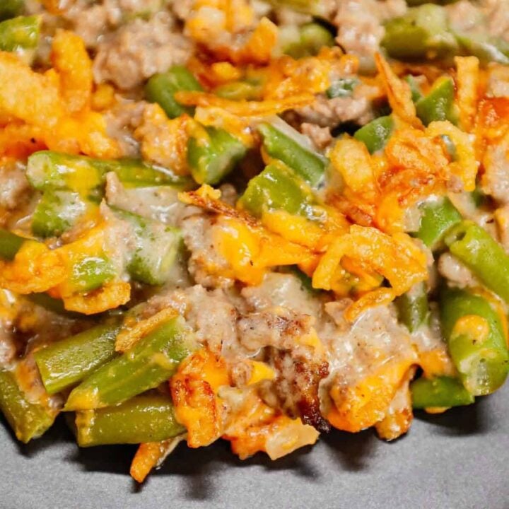 Hamburger Green Bean Casserole is a hearty ground beef casserole recipe loaded with cut green beans, cream of mushroom soup, diced onions, shredded cheddar cheese and French's crispy fried onions.