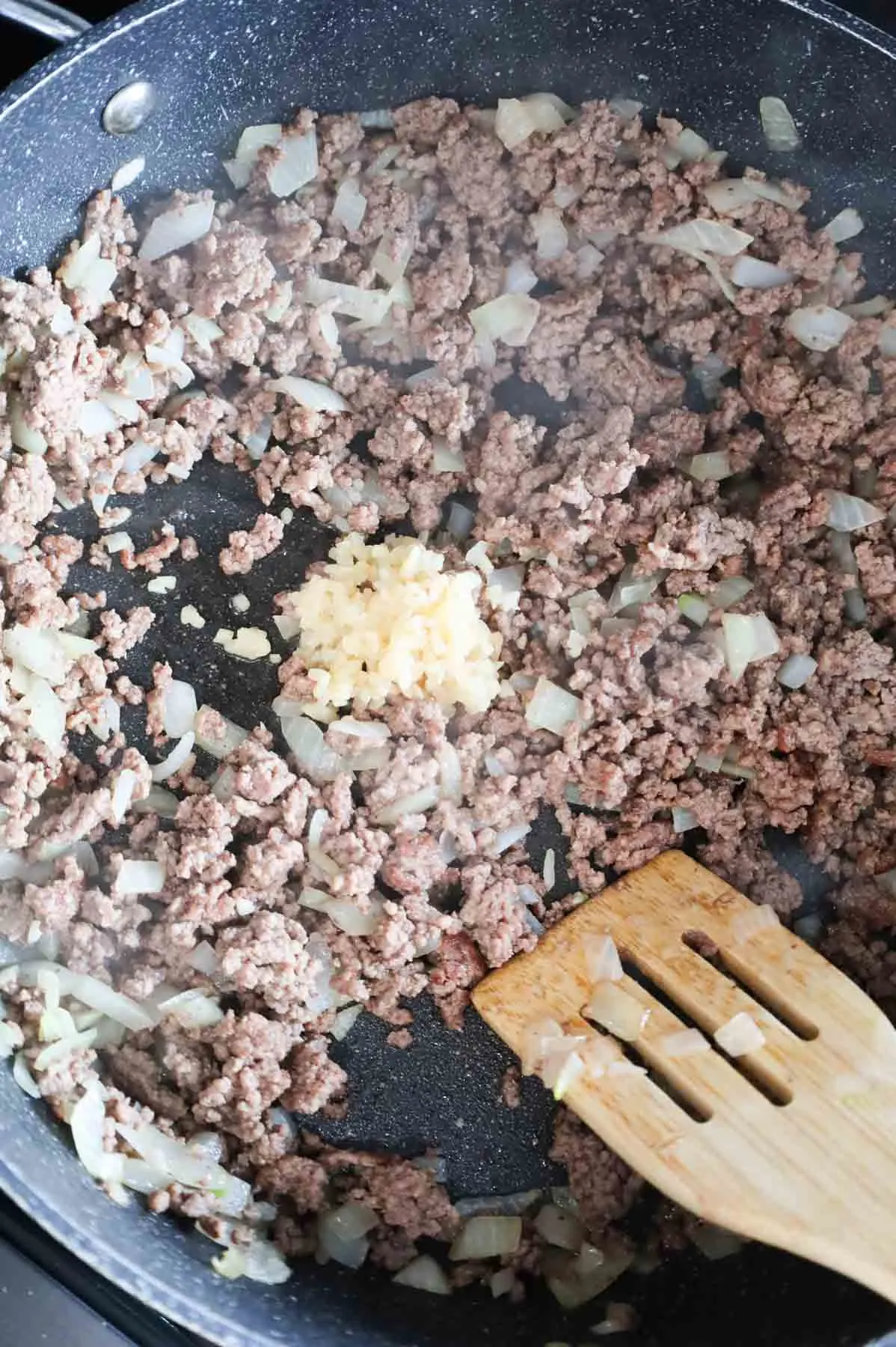 minced garlic added to skillet with cooked ground beef and diced onions