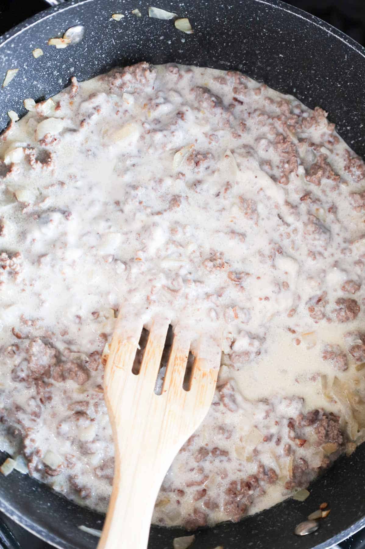 stirring creamy ground beef mixture in a skillet