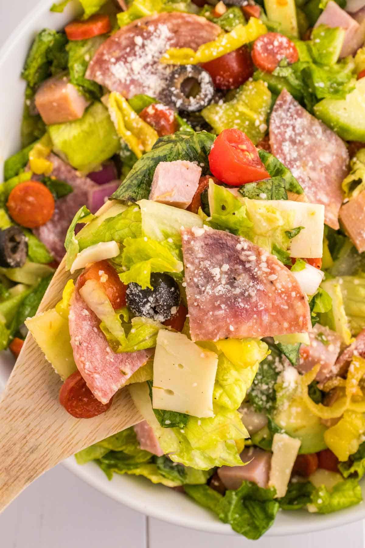 Italian Sub Salad is a delicious dish loaded with romaine, olives, tomatoes, cucumber, ham, pepperoni, peppers, onions and salami all tossed in a red wine vinegar dressing.