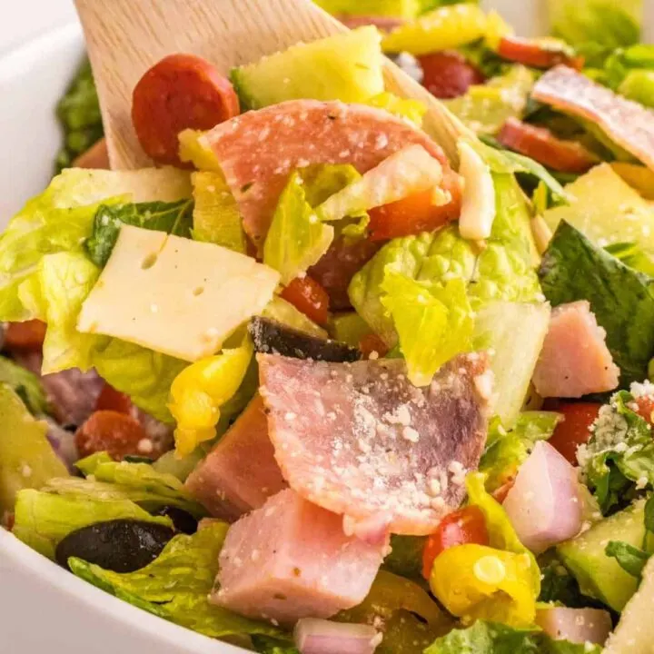 Italian Sub Salad is a delicious dish loaded with romaine, olives, tomatoes, cucumber, ham, pepperoni, peppers, onions and salami all tossed in a red wine vinegar dressing.