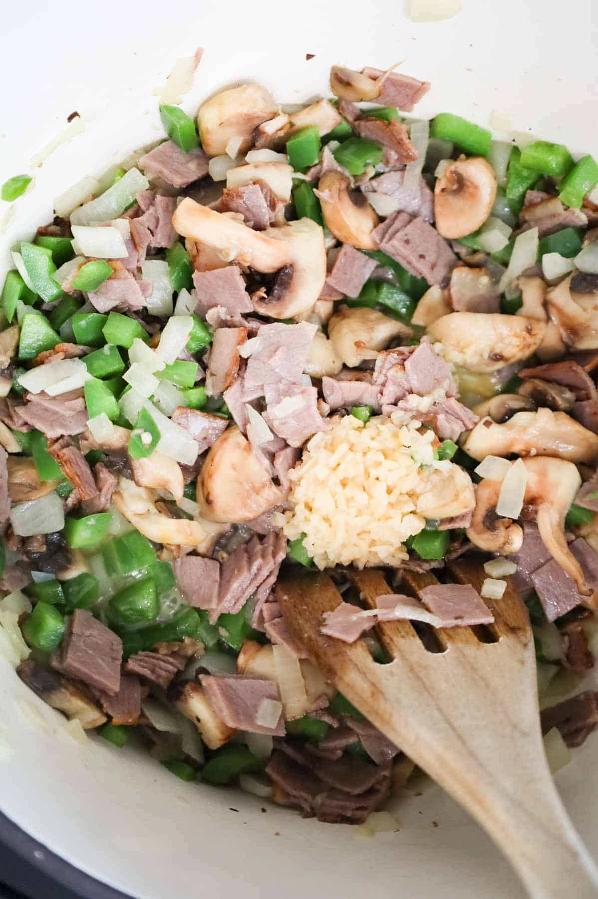 minced garlic added to skillet with chopped roast beef, sliced mushrooms, onions and green peppers