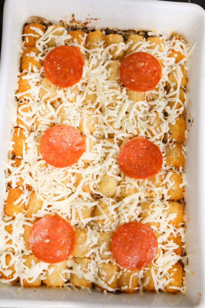 pepperoni slices and shredded mozzarella cheese on top of tater tot casserole