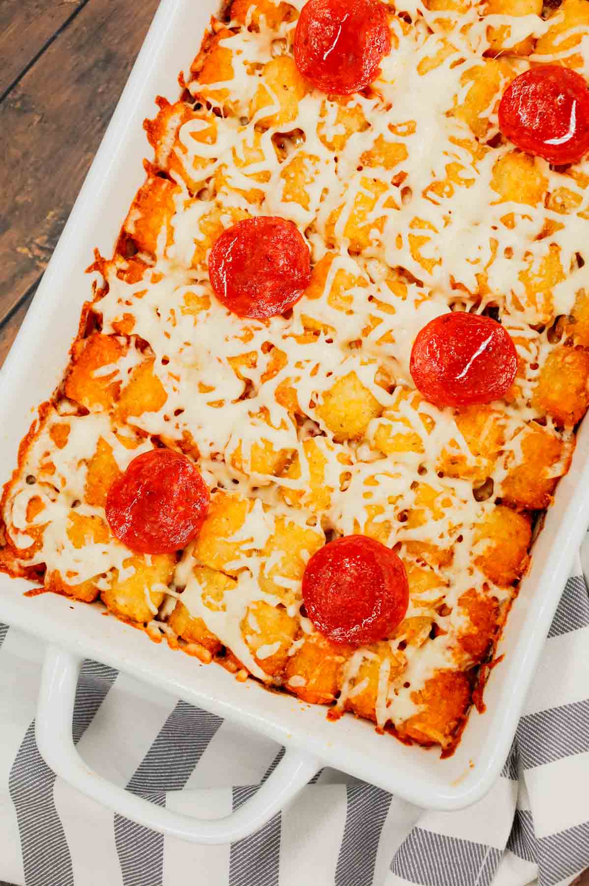 Pizza Tater Tot Casserole is a hearty casserole loaded with ground beef, Italian sausage, pepperoni, green peppers, onions, pizza sauce, mozzarella cheese and crispy tater tots.