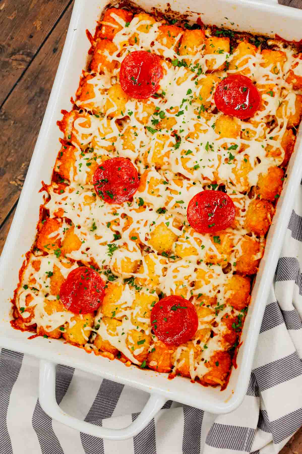 Pizza Tater Tot Casserole is a hearty casserole loaded with ground beef, Italian sausage, pepperoni, green peppers, onions, pizza sauce, mozzarella cheese and crispy tater tots.