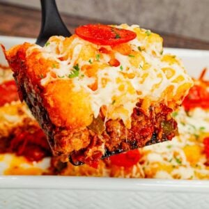 Pizza Tater Tot Casserole is a hearty casserole loaded with ground beef, Italian sausage, pepperoni, green peppers, onions, pizza sauce, mozzarella cheese and crispy tater tots.