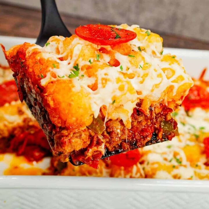 Pizza Tater Tot Casserole is a hearty casserole loaded with ground beef, Italian sausage, pepperoni, green peppers, onions, pizza sauce, mozzarella cheese and crispy tater tots.