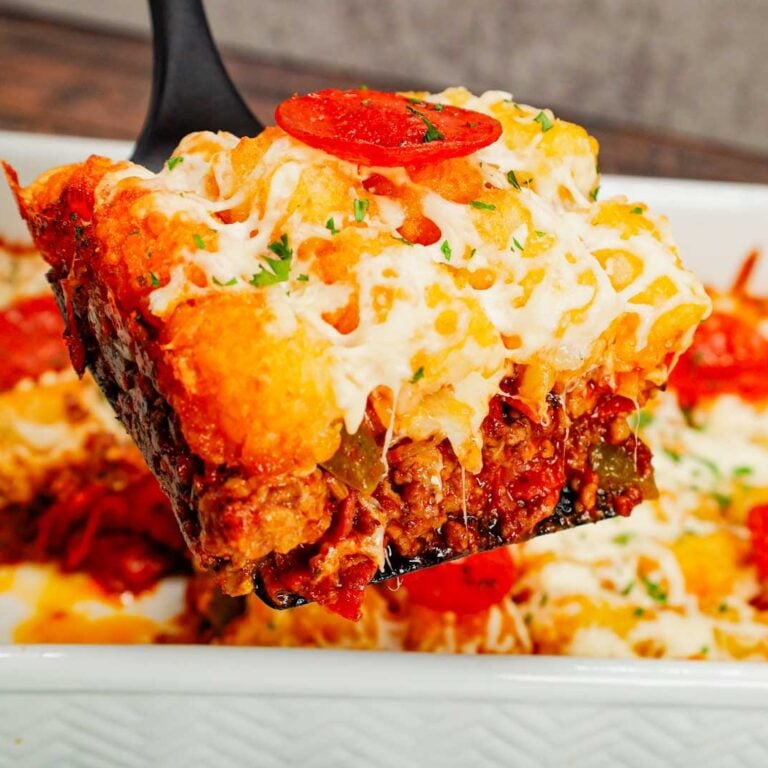 Pizza Tater Tot Casserole is a hearty casserole loaded with ground beef, Italian sausage, pepperoni, green peppers, onions, pizza sauce, mozzarella cheese and crispy tater tots.