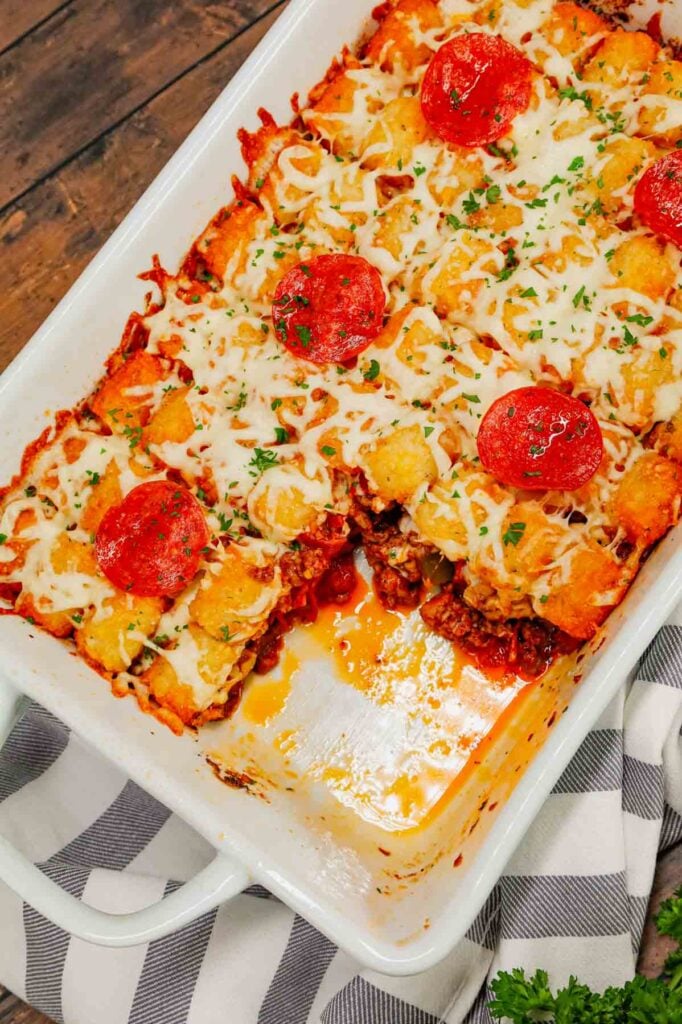 Pizza Tater Tot Casserole is a hearty casserole loaded with ground beef, Italian sausage, pepperoni, green peppers, onions, pizza sauce, mozzarella cheese and crispy tater tots.