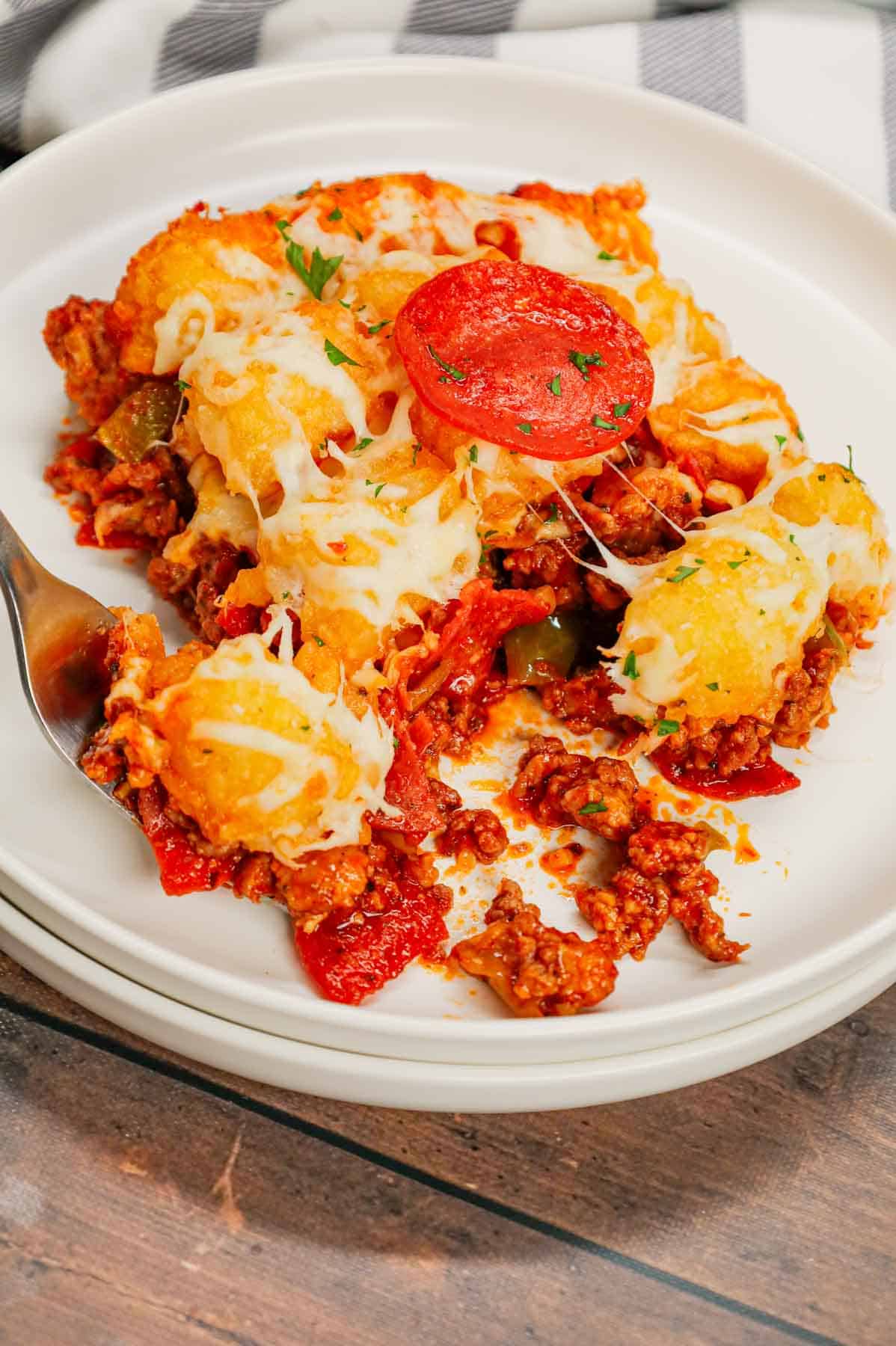 Pizza Tater Tot Casserole is a hearty casserole loaded with ground beef, Italian sausage, pepperoni, green peppers, onions, pizza sauce, mozzarella cheese and crispy tater tots.