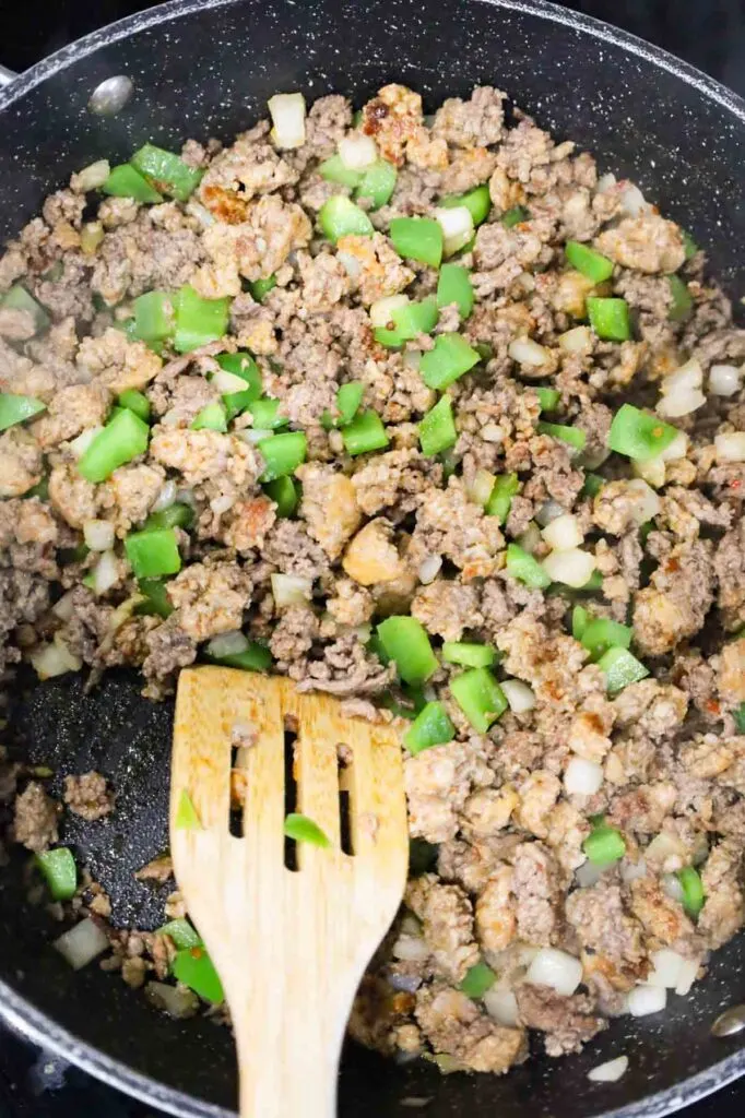 ground beef, sausage meat, onion and green peppers cooking in a skillet