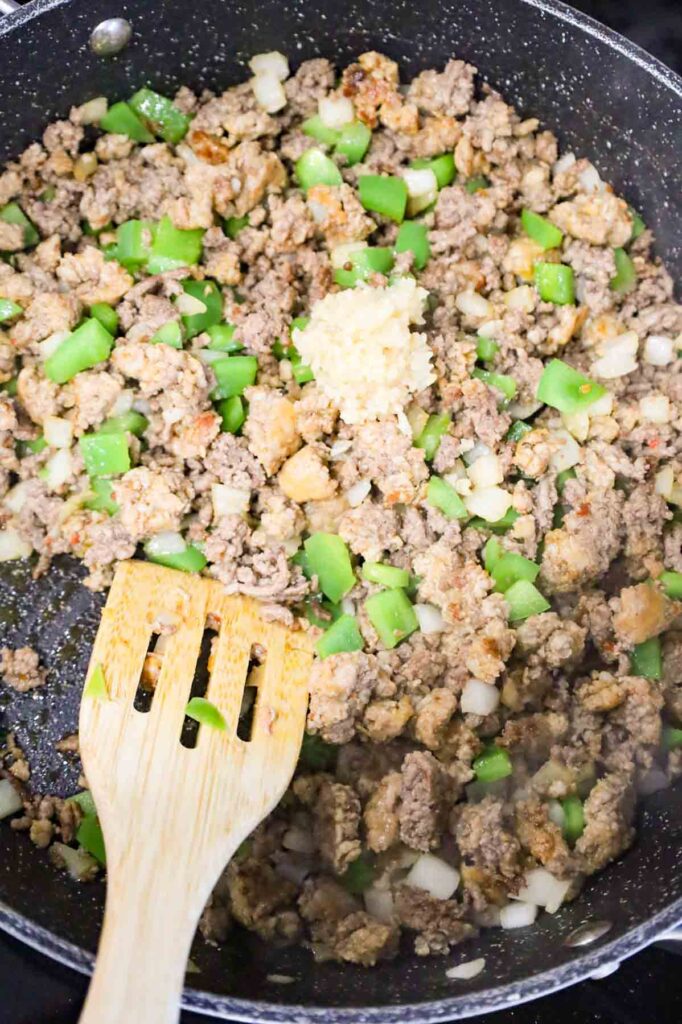 minced garlic added to skillet with cooked ground beef and sausage meat