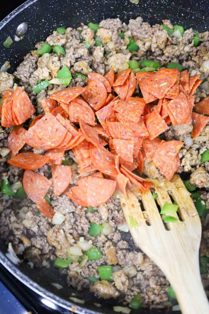 pepperoni pieces added to skillet with cooked ground beef and sausage meat