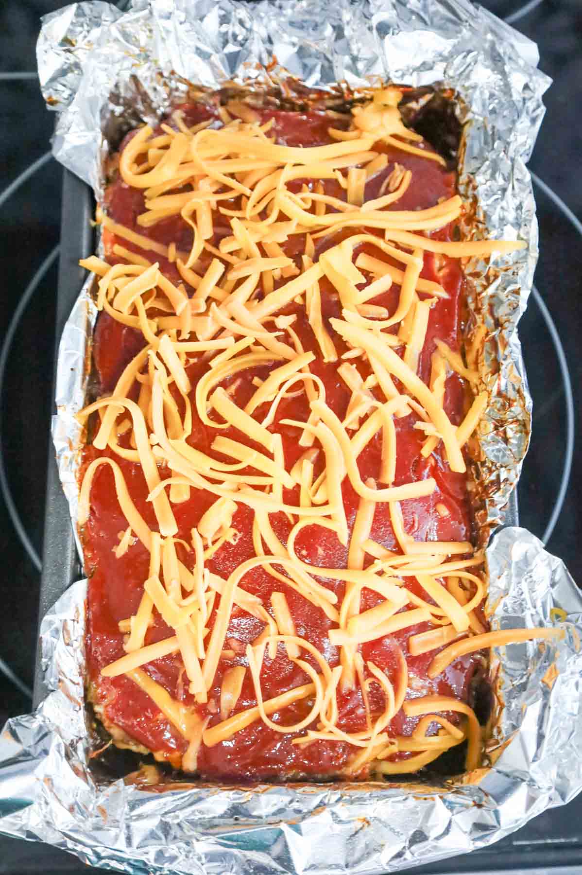 shredded cheddar cheese on top of meatloaf
