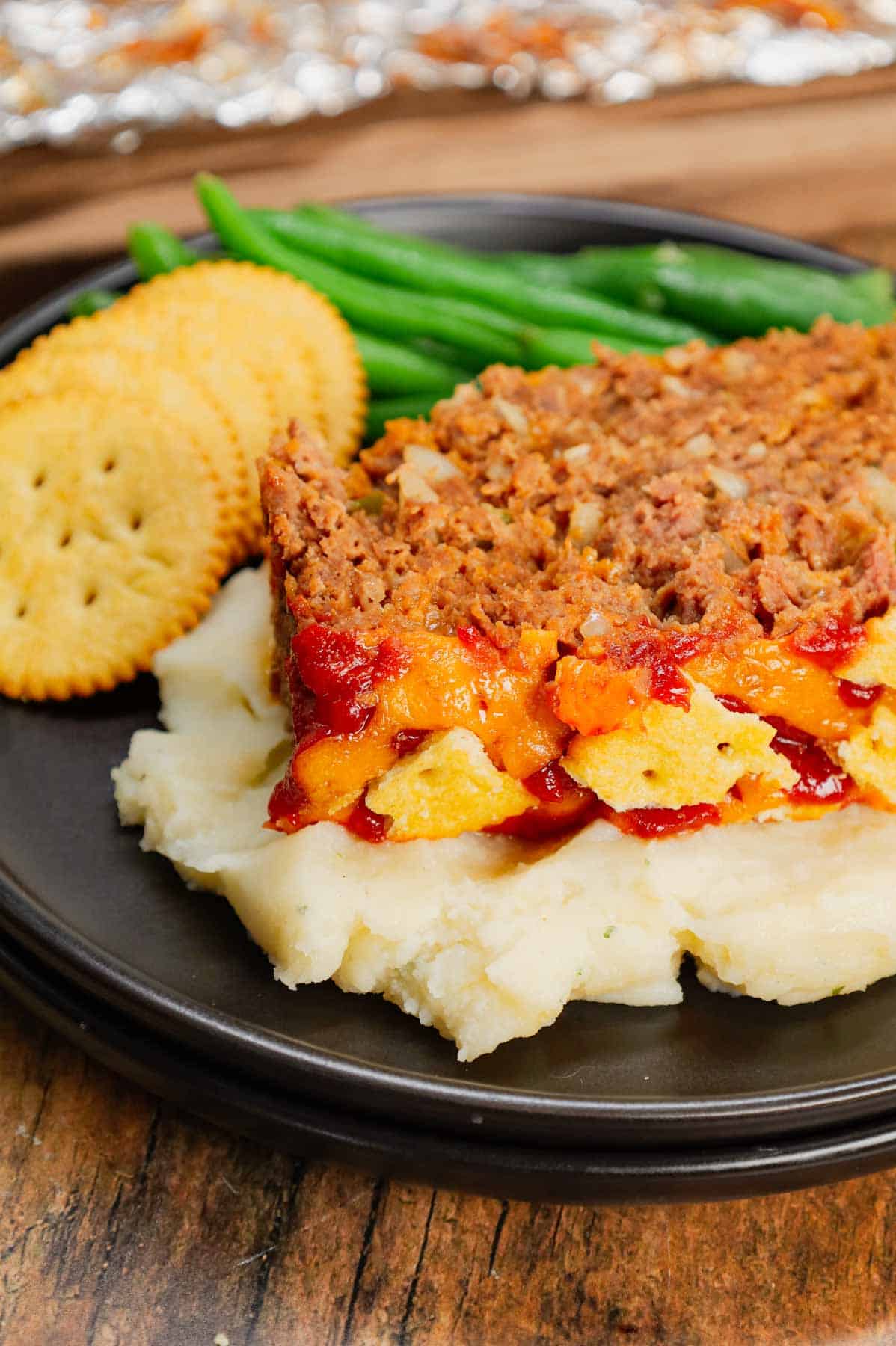 Ritz Cracker Meatloaf is a delicious ground beef meatloaf loaded with crushed Ritz crackers, onion soup mix, onions, green bell peppers and cheddar cheese.