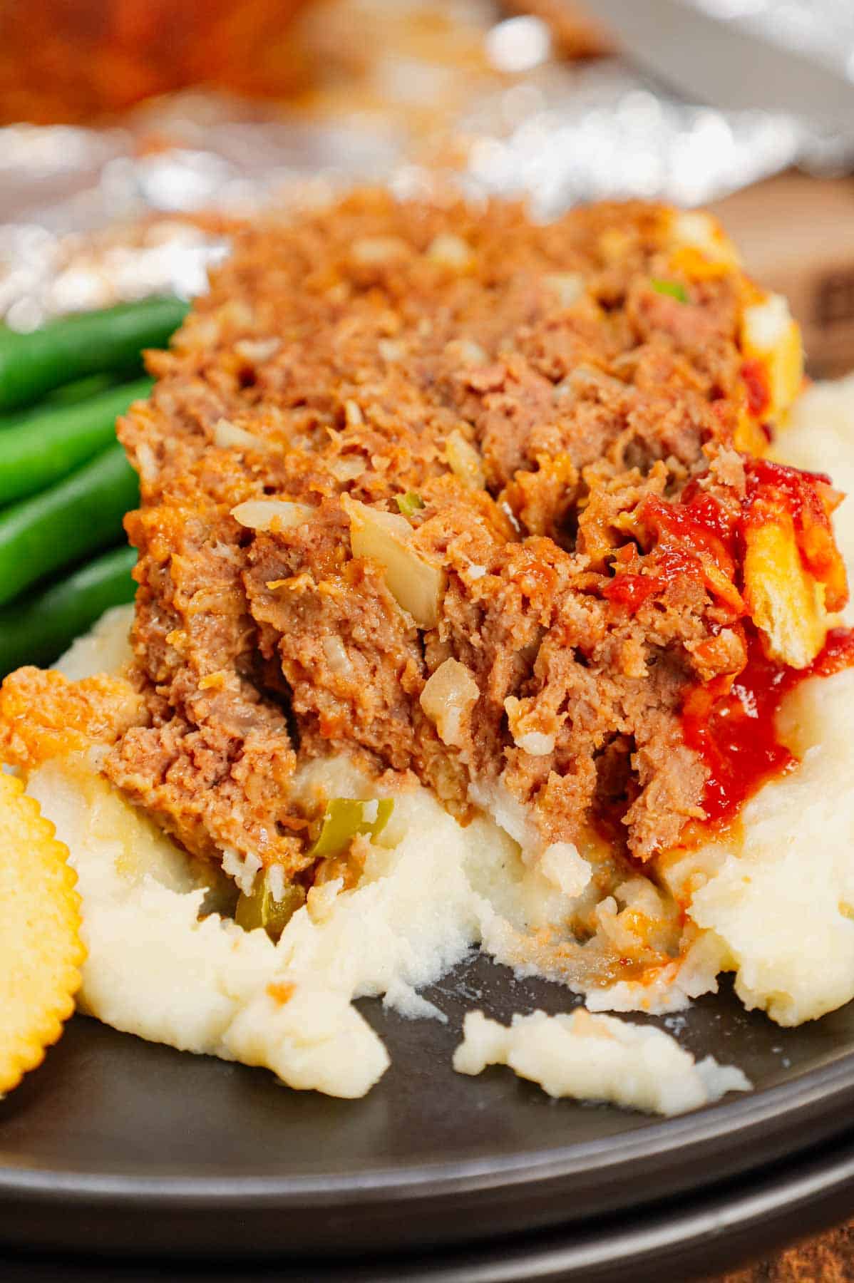 Ritz Cracker Meatloaf is a delicious ground beef meatloaf loaded with crushed Ritz crackers, onion soup mix, onions, green bell peppers and cheddar cheese.