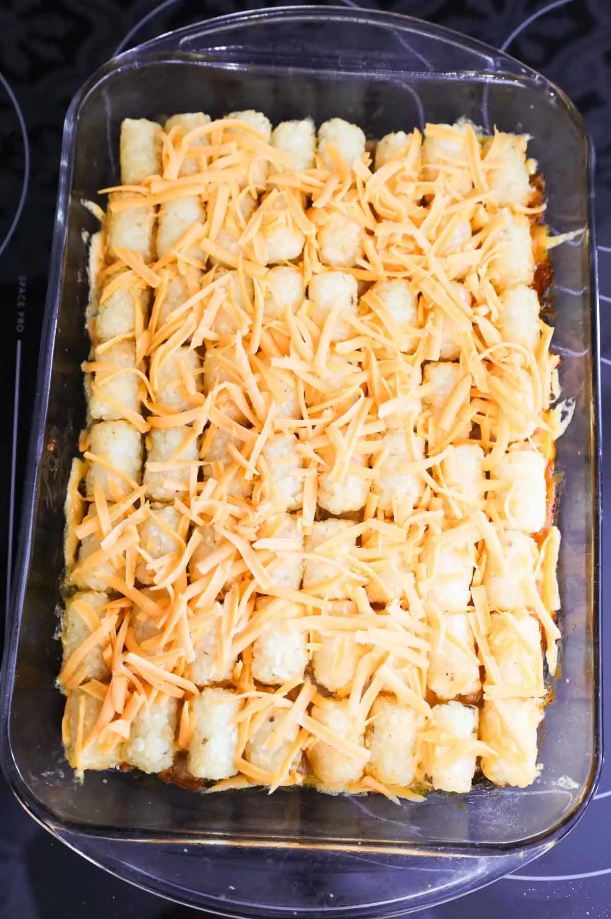 shredded cheddar cheese on top of tater tot casserole