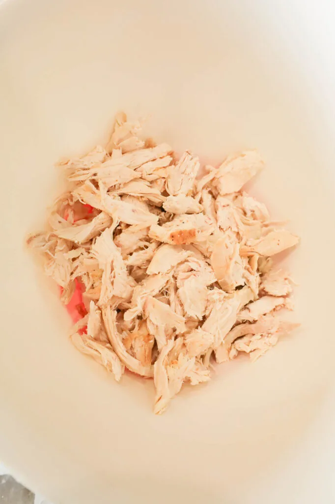 shredded rotisserie chicken in a mixing bowl