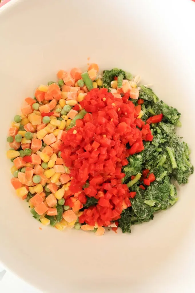 diced pimentos, chopped spinach and frozen mixed vegetables in a mixing bowl