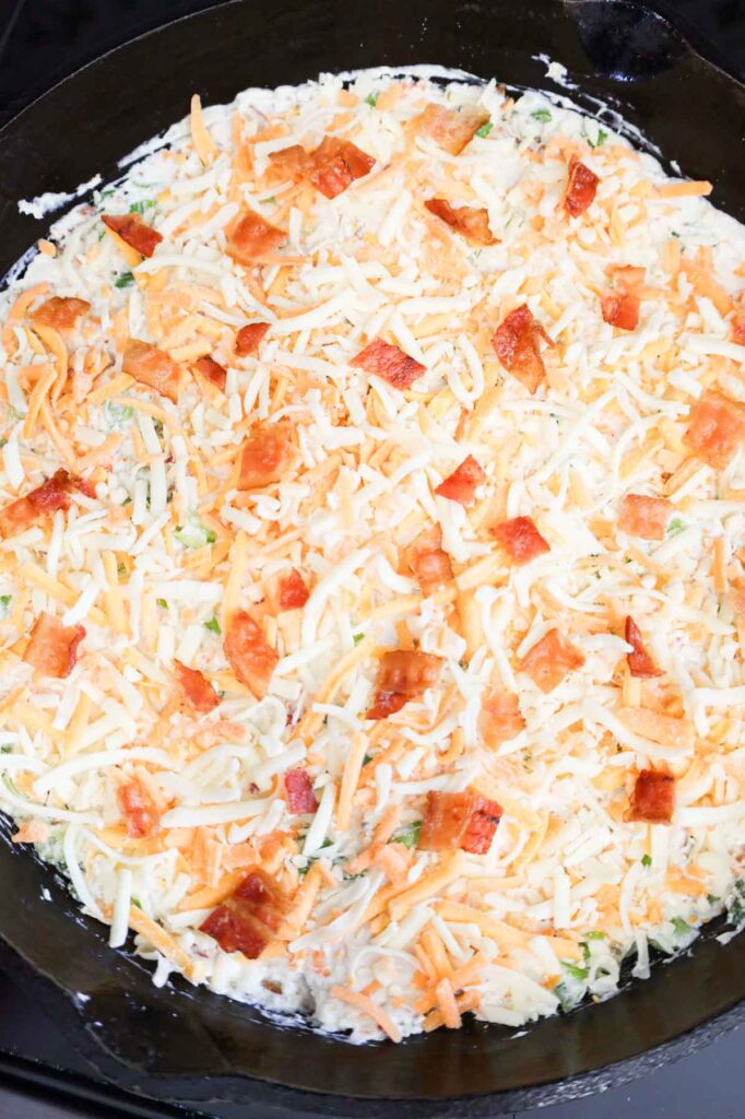 chopped bacon and shredded cheddar cheese on top of crack chicken dip
