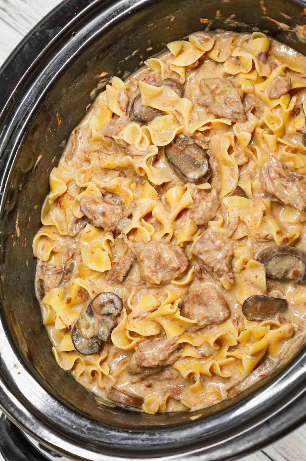 Crock Pot Beef Stroganoff is a hearty slow cooker dinner recipe loaded with tender chunks of stewing beef, sliced mushrooms, onions and egg noodles all in a delicious beef broth and cream of mushroom sauce.