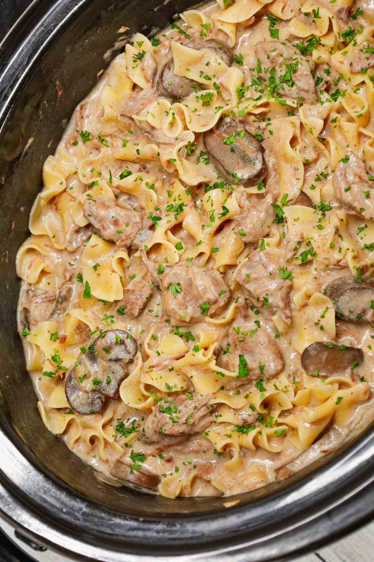 Crock Pot Beef Stroganoff is a hearty slow cooker dinner recipe loaded with tender chunks of stewing beef, sliced mushrooms, onions and egg noodles all in a delicious beef broth and cream of mushroom sauce.