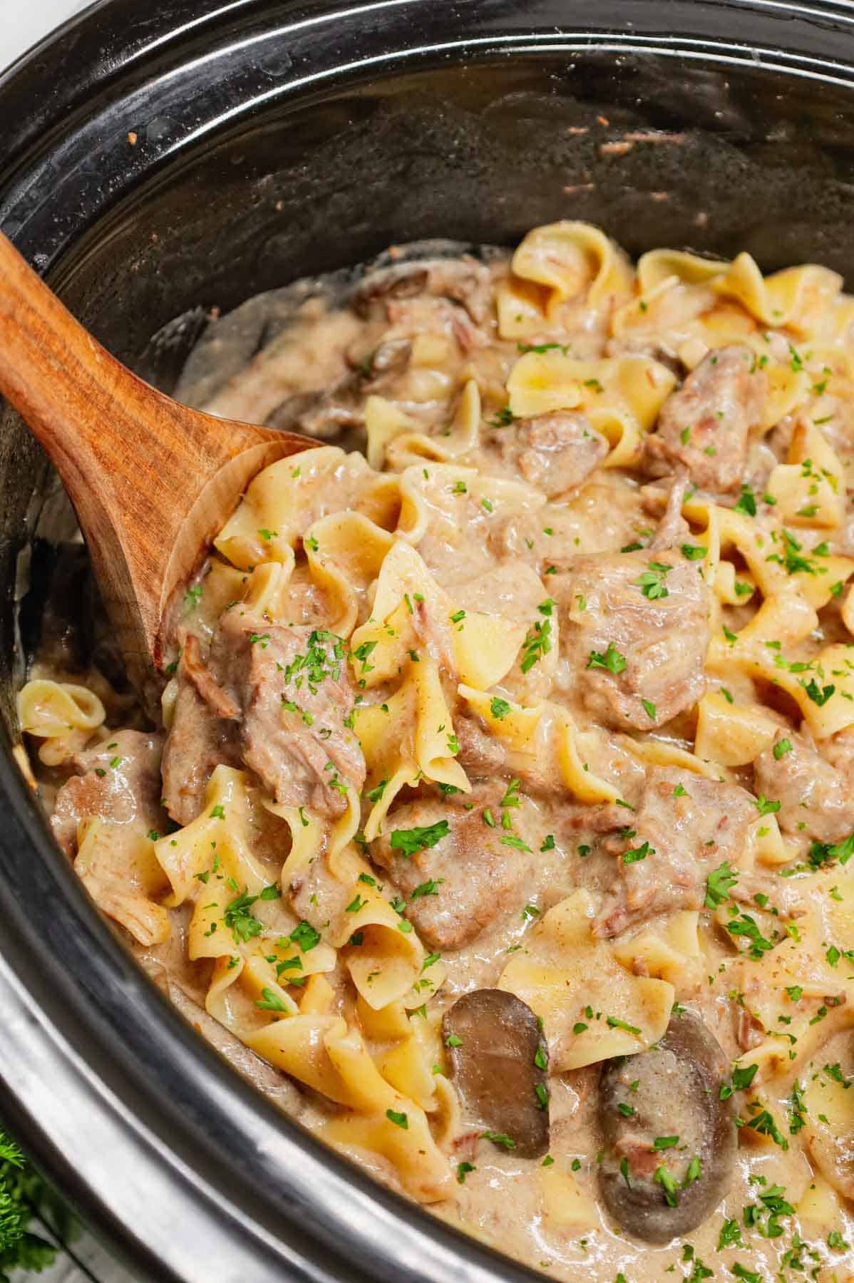 Crock Pot Beef Stroganoff is a hearty slow cooker dinner recipe loaded with tender chunks of stewing beef, sliced mushrooms, onions and egg noodles all in a delicious beef broth and cream of mushroom sauce.