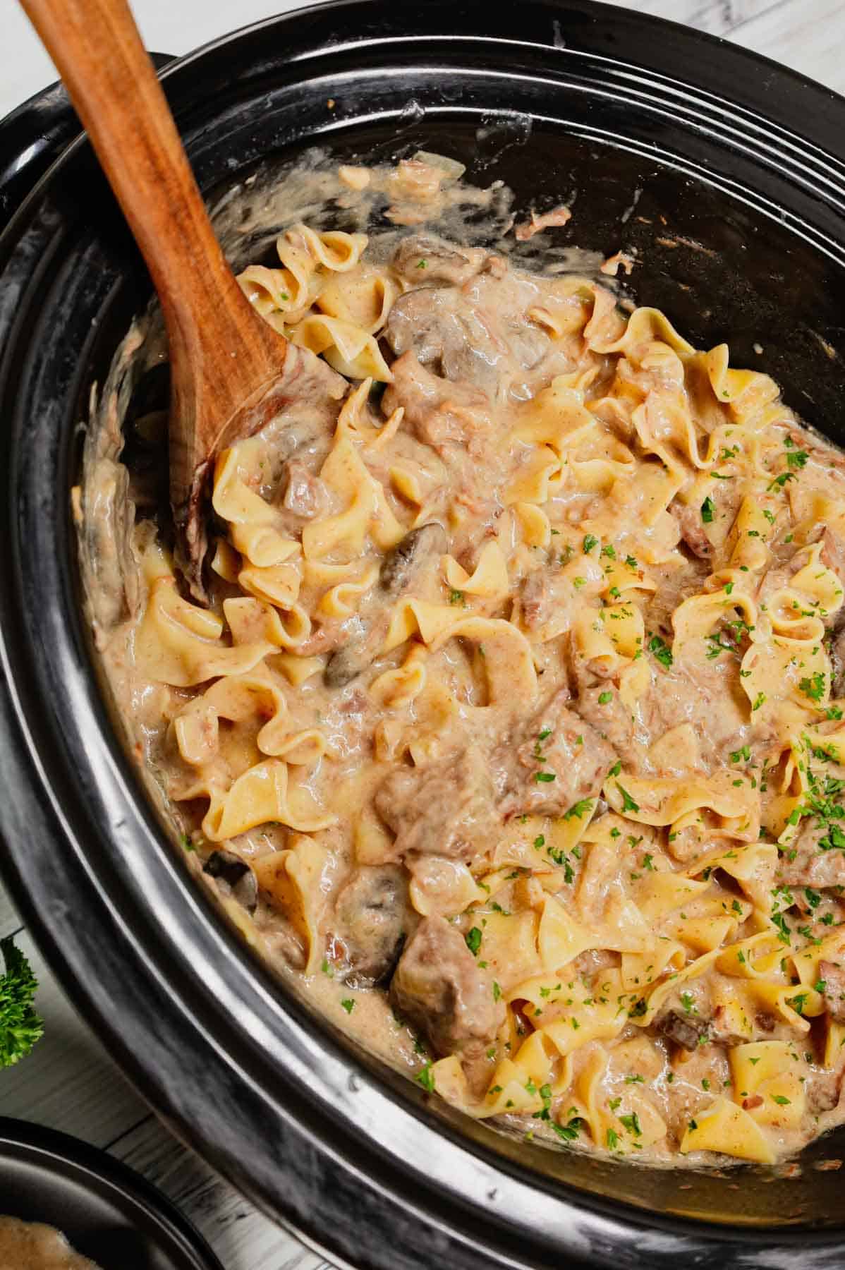 Crock Pot Beef Stroganoff is a hearty slow cooker dinner recipe loaded with tender chunks of stewing beef, sliced mushrooms, onions and egg noodles all in a delicious beef broth and cream of mushroom sauce.