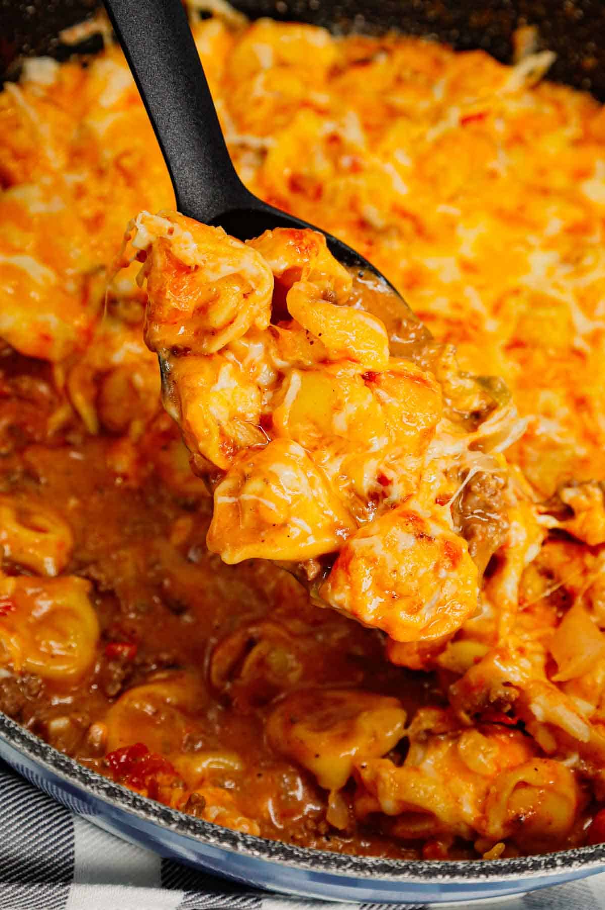 Cheeseburger Tortellini Skillet is a hearty pasta dish loaded with ground beef, frozen cheese tortellini, diced onions, cheddar soup, Rotel and shredded cheddar cheese.
