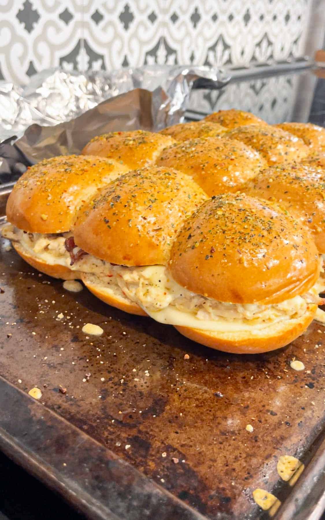 Garlic Parmesan Chicken Sliders are a delicious mini sandwich recipe loaded with shredded rotisserie chicken, bacon, provolone, mozzarella, cream cheese and Buffalo Wild Wings Parmesan Garlic Sauce.