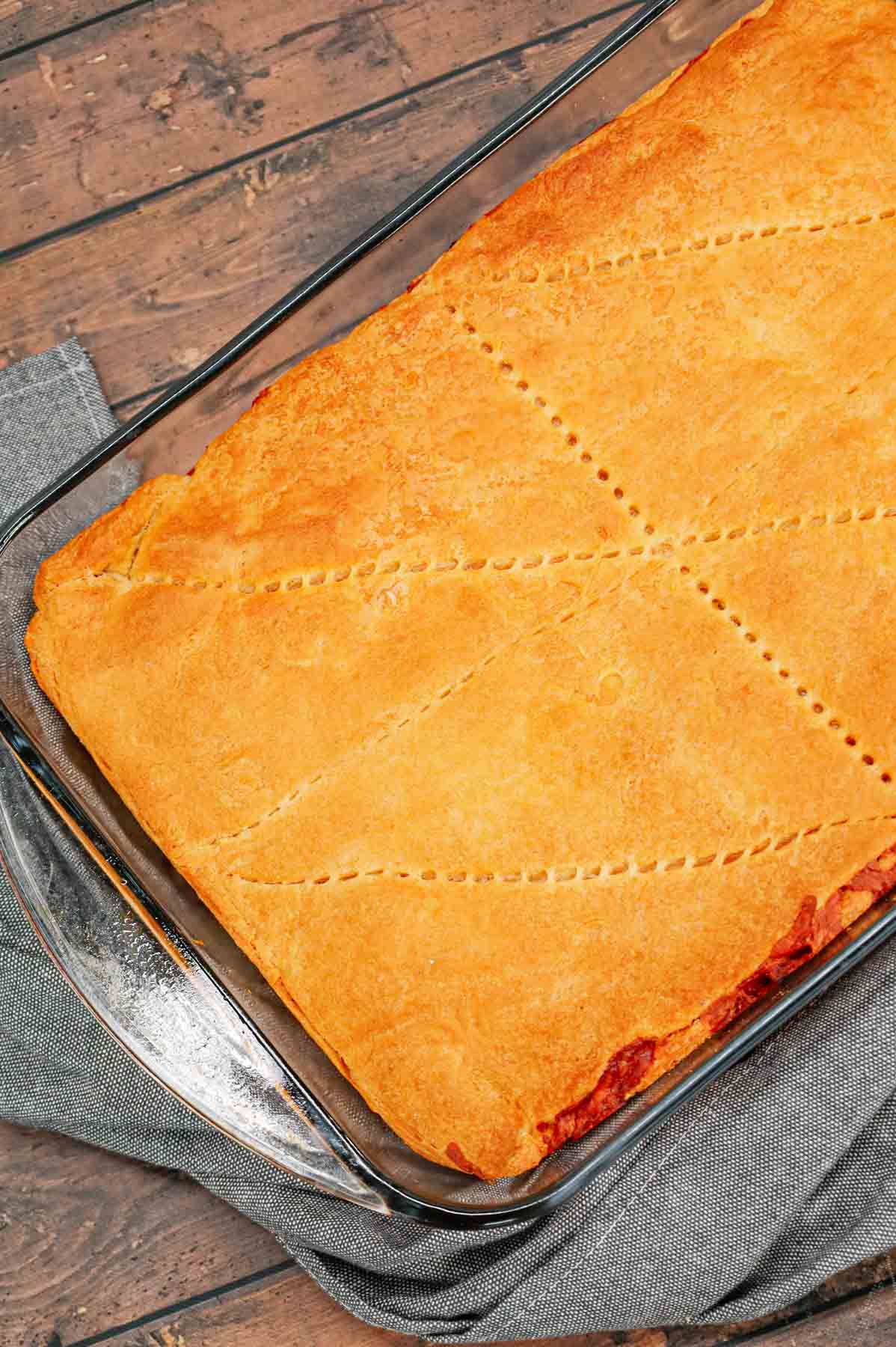 Crescent Roll Cheeseburger Casserole is a hearty ground beef dinner recipe made with layers of Pillsbury crescent roll dough and a ground beef filling loaded with onions, pickles, tomatoes, ketchup, mustard and shredded cheese.