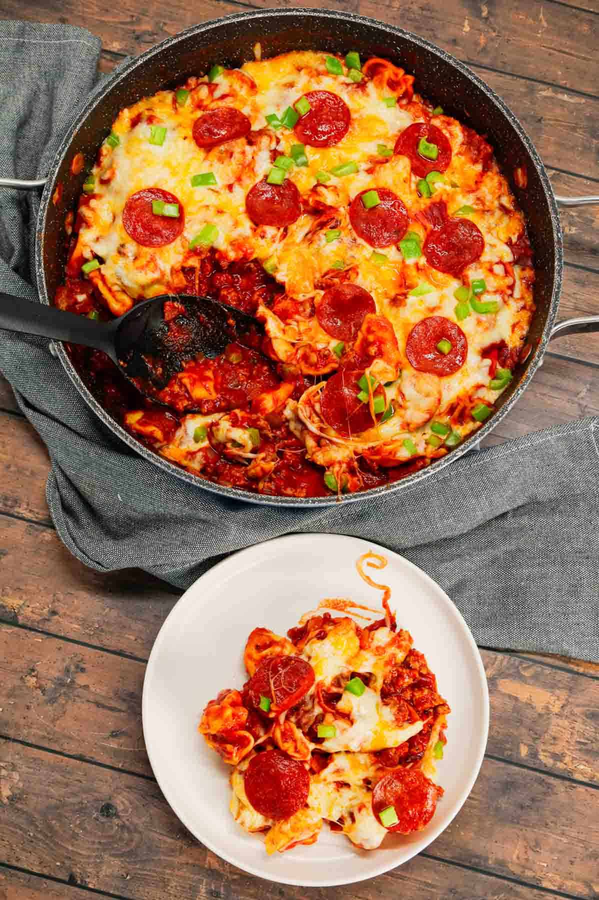 Pizza Tortellini is a hearty pasta dish loaded with Italian sausage meat, cheese tortellini, diced onions, green peppers, pepperoni, pizza sauce, pasta sauce and mozzarella cheese.