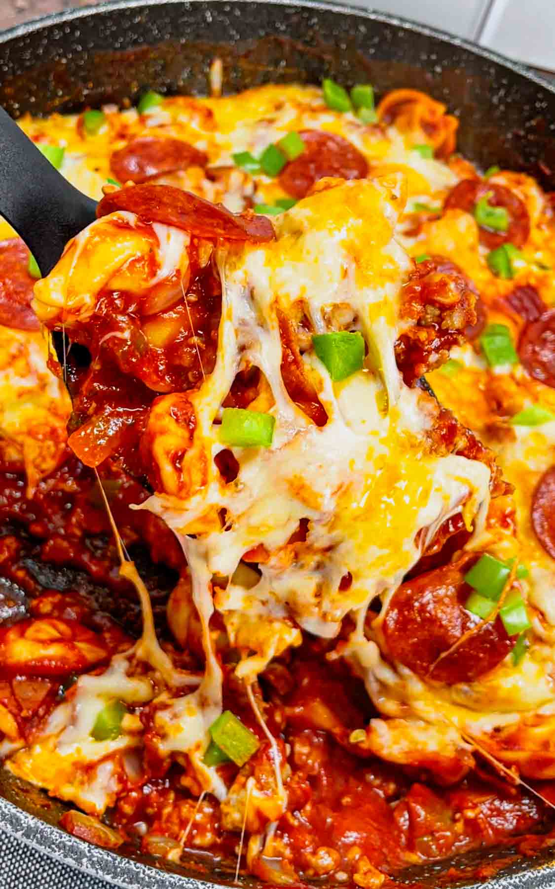 Pizza Tortellini is a hearty pasta dish loaded with Italian sausage meat, cheese tortellini, diced onions, green peppers, pepperoni, pizza sauce, pasta sauce and mozzarella cheese.