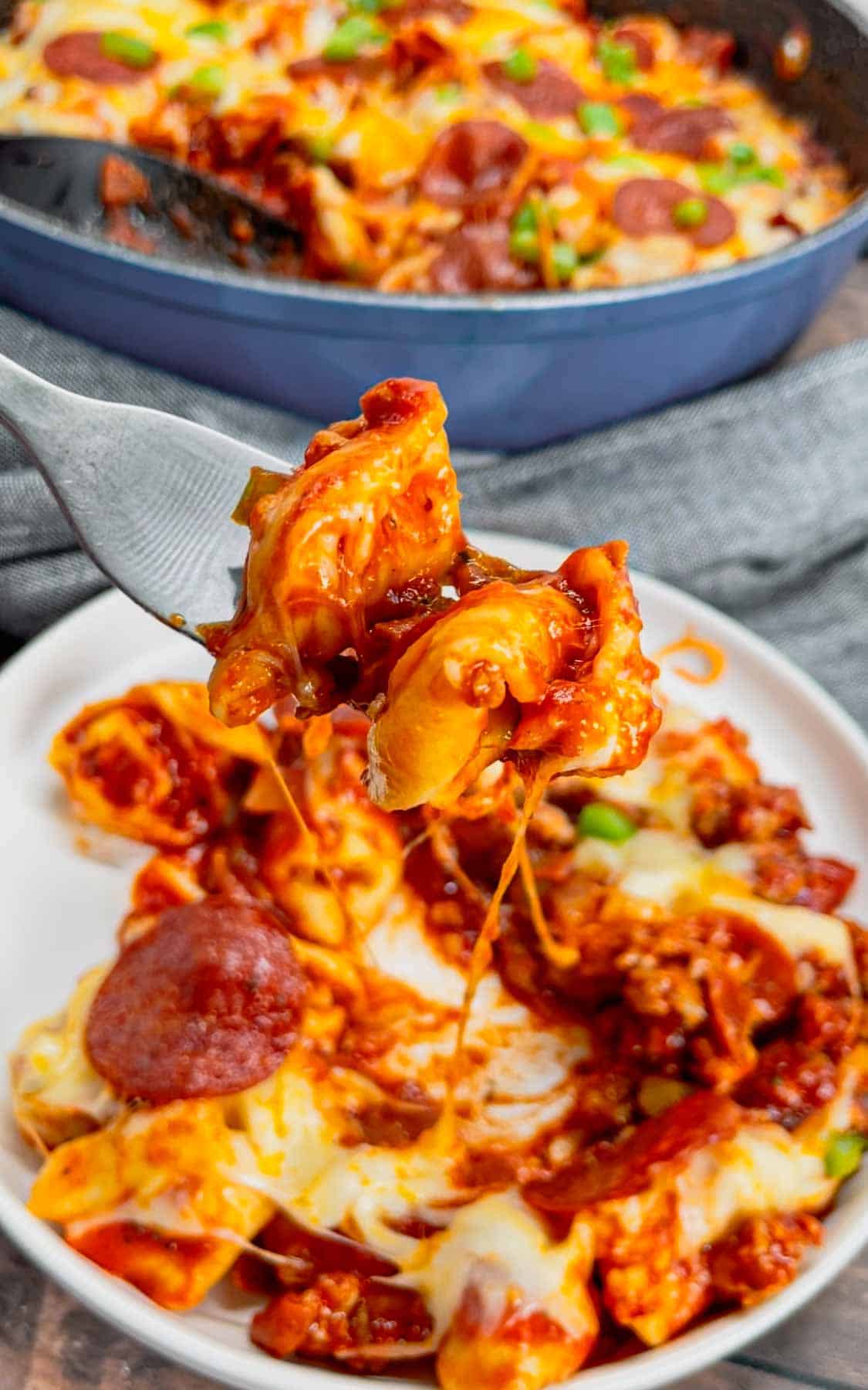 Pizza Tortellini is a hearty pasta dish loaded with Italian sausage meat, cheese tortellini, diced onions, green peppers, pepperoni, pizza sauce, pasta sauce and mozzarella cheese.